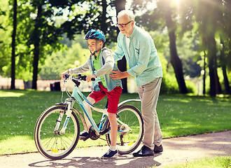 Image showing grandfather and boy with bicycle at summer park