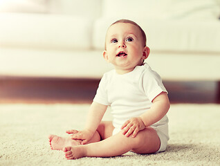 Image showing happy baby boy or girl sitting on floor at home