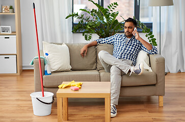 Image showing man calling on smartphone after cleaning home