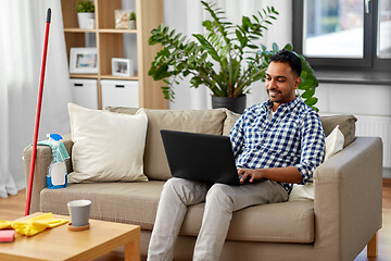 Image showing man with laptop computer after home cleaning