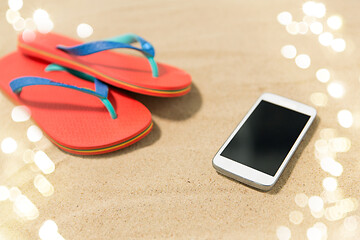 Image showing smartphone and flip flops on beach sand