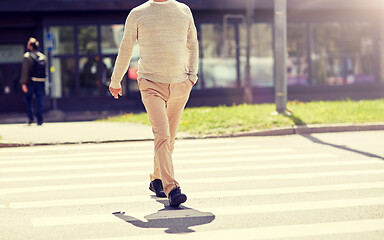 Image showing senior man walking along city crosswalk