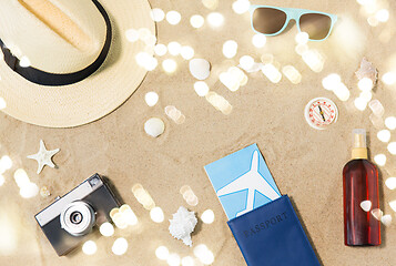 Image showing travel tickets, camera and hat on beach sand