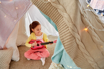 Image showing little girl playing guitar in kids tent at home