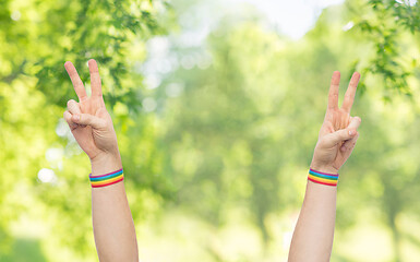 Image showing hands with gay pride rainbow wristbands make peace