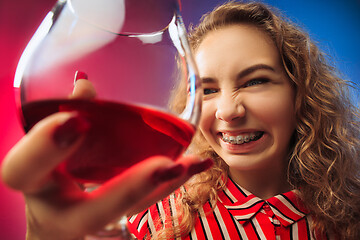 Image showing The sad young woman in party clothes posing with glass of wine.