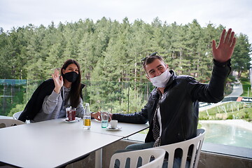 Image showing couple in restaurant wearing corona virus  medical protective fa