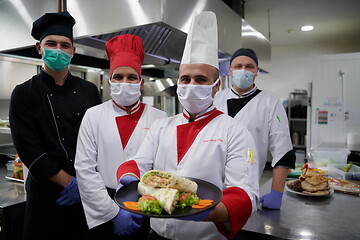 Image showing group chefs standing together in the kitchen at restaurant weari