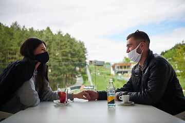 Image showing couple in restaurant wearing corona virus  medical protective fa