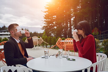 Image showing couple with protective medical mask  having coffee break in a re