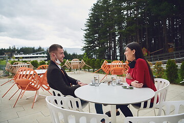 Image showing couple with protective medical mask  having coffee break in a re