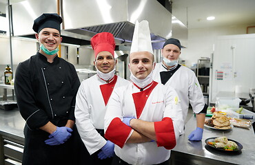 Image showing group chefs standing together in the kitchen at restaurant weari