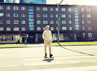 Image showing senior man walking along city crosswalk