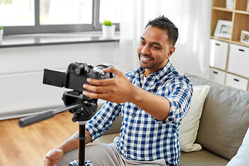 Image showing indian male video blogger adjusting camera at home