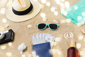 Image showing money in passport, shades and hat on beach sand