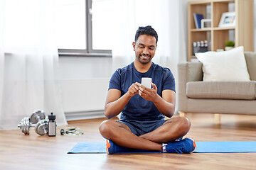 Image showing indian man with smartphone on exercise mat at home