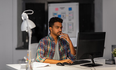 Image showing creative man with computer working at night office