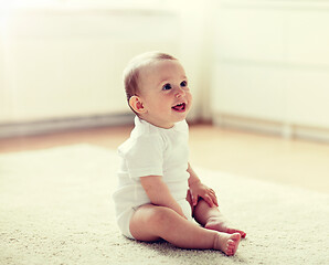 Image showing happy baby boy or girl sitting on floor at home