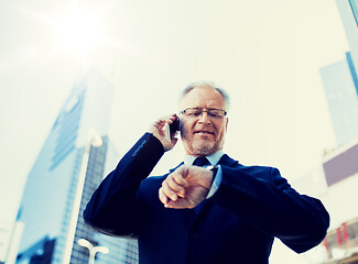 Image showing senior businessman calling on smartphone in city