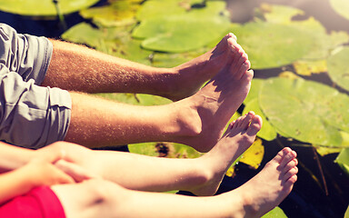 Image showing grandfather and grandson feet over river