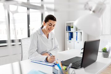 Image showing doctor with laptop and medical report at hospital