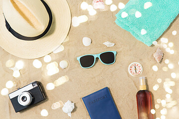 Image showing camera, passport, sunglasses and hat on beach sand