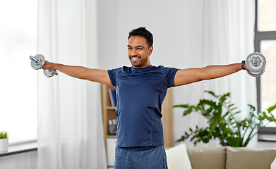 Image showing indian man exercising with dumbbells at home