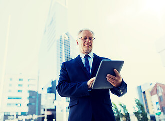 Image showing senior businessman with tablet pc on city street