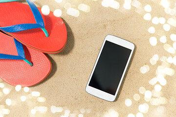 Image showing smartphone and flip flops on beach sand