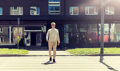 Image showing senior man walking along city crosswalk