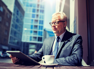 Image showing senior businessman with tablet pc drinking coffee