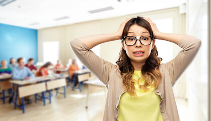 Image showing stressed female student holding to head at school