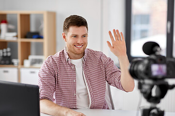 Image showing male blogger with camera videoblogging at home