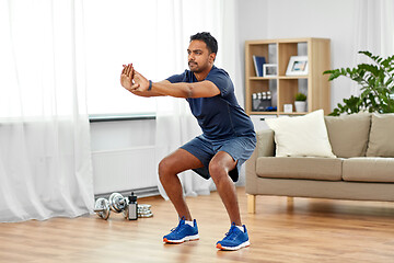 Image showing indian man exercising and doing squats at home