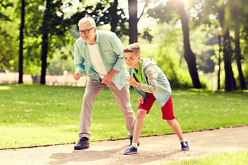 Image showing grandfather and grandson racing at summer park