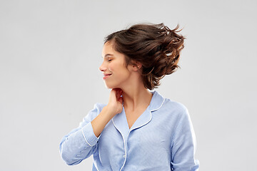 Image showing happy young woman in pajama over grey background