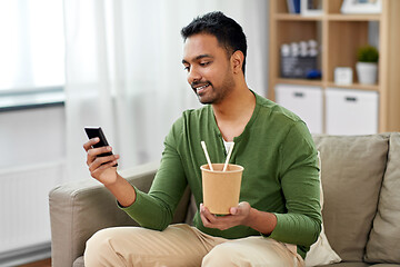 Image showing smiling indian man eating takeaway food at home