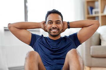 Image showing indian man making abdominal exercises at home