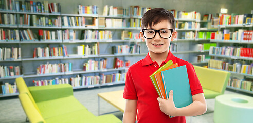 Image showing schoolboy in glasses with books at library