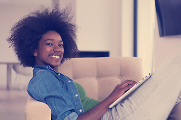 Image showing African American women at home in the chair using a laptop