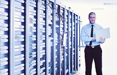 Image showing businessman with laptop in network server room