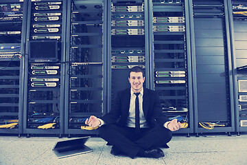 Image showing business man practice yoga at network server room