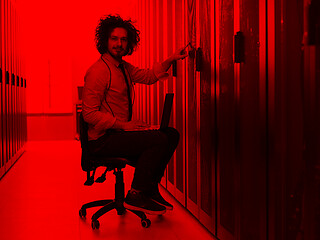 Image showing engineer working on a laptop in server room