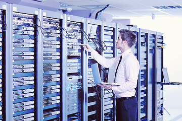 Image showing businessman with laptop in network server room