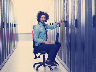 Image showing engineer working on a laptop in server room