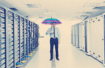 Image showing businessman hold umbrella in server room