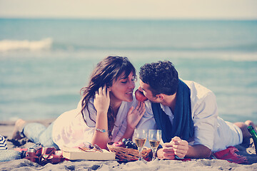 Image showing young couple enjoying  picnic on the beach