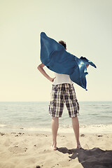 Image showing funny superhero standing on beach