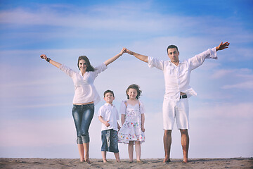 Image showing family on beach showing home sign