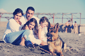 Image showing happy family playing with dog on beach